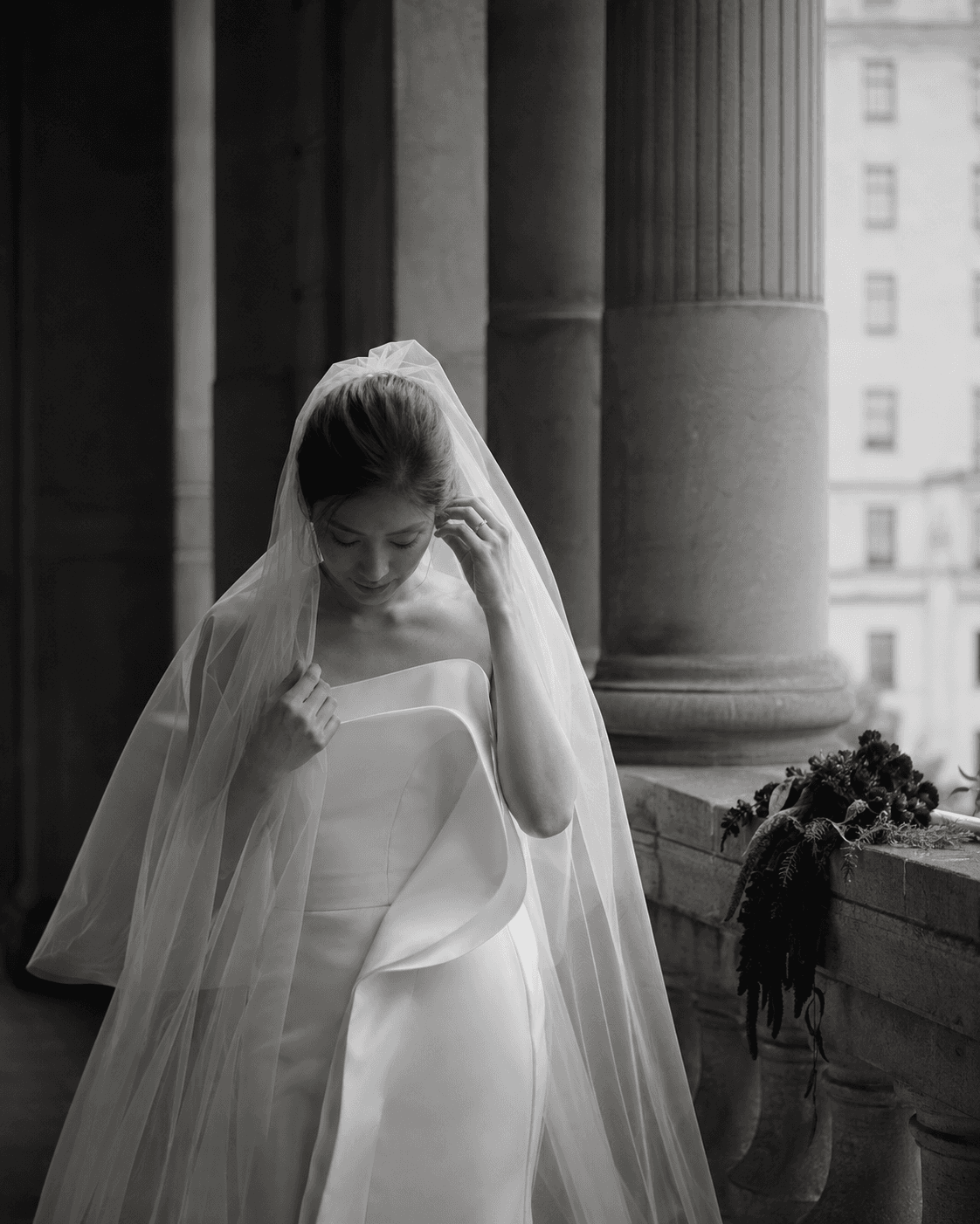 An editorial bridal portrait in a quiet stone arcade