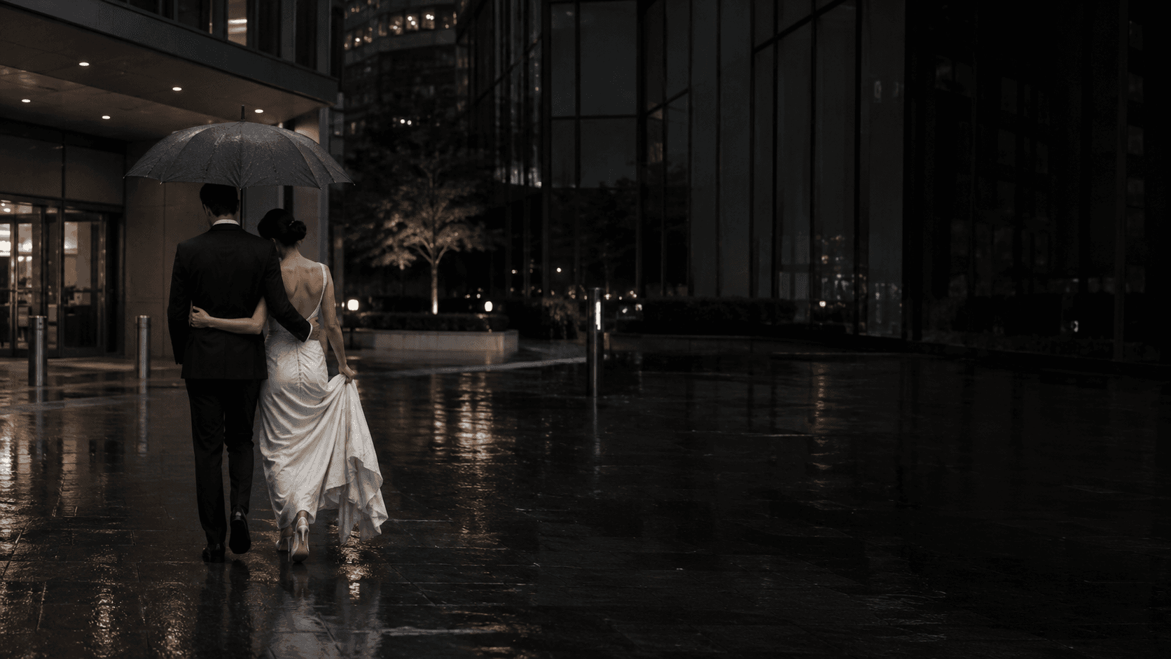 A newly married couple walking beneath an umbrella in Vancouver